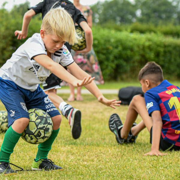 Kinderen doen mee aan freestyle voetbal workshop op camping